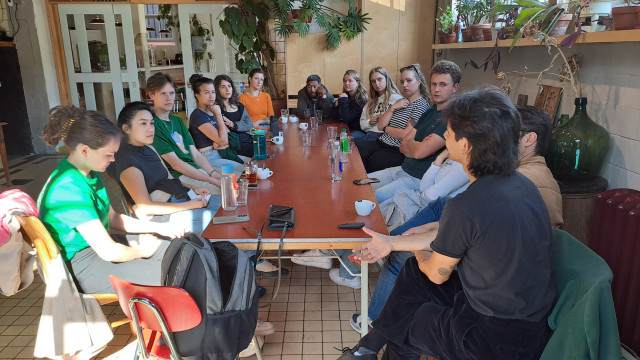 Foto van een groep jonge mensen aan een lange tafel
